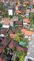 Aerial view of traditional Balinese rooftops, tropical gardens, and villas in Ubud, Bali. Peaceful residential view showing dense greenery and orange-tile architecture. video
