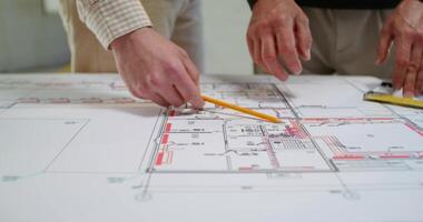 Two men are discussing a house construction project. They are talking standing next to a table photo