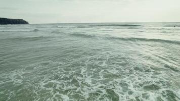 The sea with large waves. Rocks on the shore in the distance photo