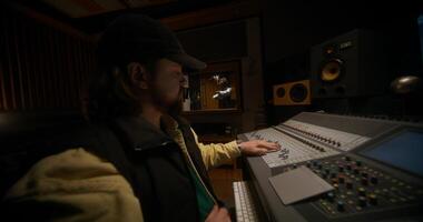 Working in a recording studio. A music engineer controls an audio mixer when rapper records a song photo