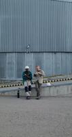 Two workers are eating while sitting on a ramp near the factory. Lunch break at the factory. photo
