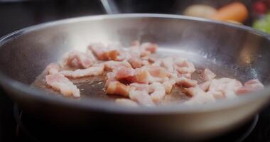 Bacon is fried in a frying pan photo