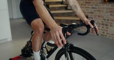 A man in sportswear is engaged on an indoor exercise bike photo