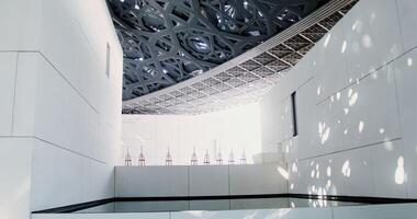 Abu Dhabi, UAE, 2025 - A white minimalistic museum building with empty easels on display. Abstract structure with an openwork ceiling photo