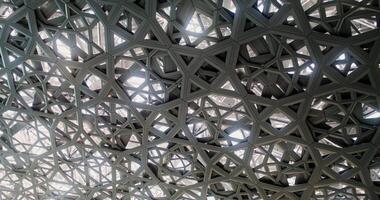 Abu Dhabi, UAE, 2025 - Close-up of the openwork dome of the Abu Dhabi Museum of Art in Dubai. The camera is spinning photo