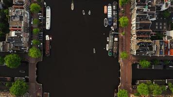 View of the pier with moored ships on the canal in Amsterdam. Drone moves along the channel. Amsterdam, Netherlands photo