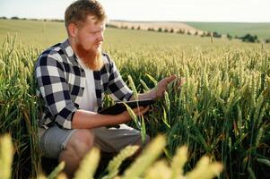 On the work,,, with ,digital tablet. Man in white shirt is on the agricultural field photo