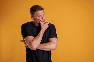 Hard ,thinking, looking, to,, the side of copy space. Man is against background in the studio photo