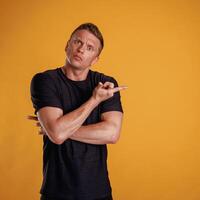Showing to the side, pointing.... Man is against background in the studio photo