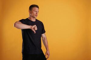 Unsatisfied,,, showing dislike. Man is against background in the studio photo