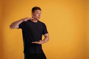 Holding copy space invisible banner,, in ,hands. Man is against background in the studio photo