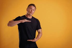 Holding, copy,, space invisible ,,banner ,in ,hands. Man is against background in the studio photo