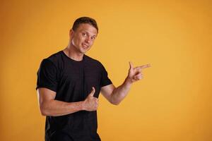 Copy ,space concept, showing,, pointing. Man is against background in the studio photo