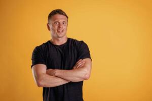 Standing with arms crossed. Man ,is ,against, background in the studio photo