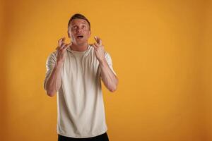 Fingers ,,,crossed, hoping for the luck. Man is against background in the studio photo