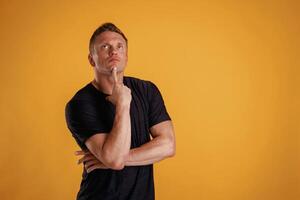 Smart, thinking and looking up. Man is against background in the studio photo
