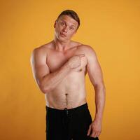 Take,, a l,ook to the side, copy space, shirtless. Man is against background in the studio photo