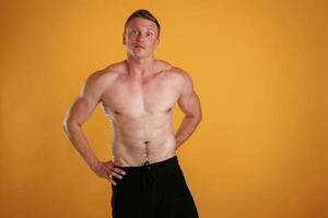 Shirtless,,, standing. Man, is ,against background in the studio photo
