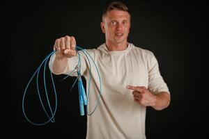 Try ,this, showing jumping, ropes, fitness. Man is against background in the studio photo