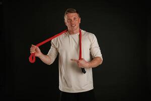 Red, jump ropes, endurance and sport concept. Man is against background in the studio photo
