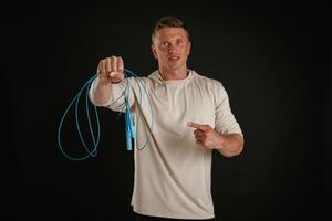 Try, this, showing jumping ropes, fitness. Man is against background in the studio photo
