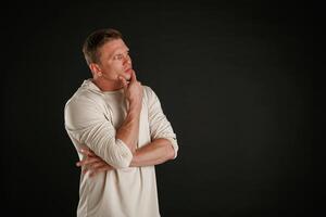 Do you have, any idea, standing and thinking. Man is against background in the studio photo