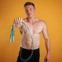 Blue jumping rope, fitness,, conception. Man is against background in the studio photo