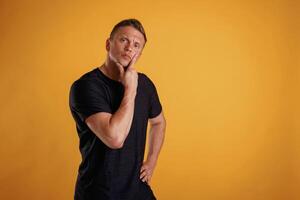 Thoughtful facial ,,expression. Man is against background in the studio photo