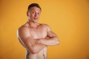 Shirtless,,, standing. Man is against background in the studio photo