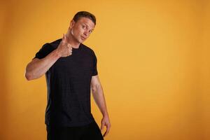 Very nice, showing thumb up. Man is against background in the studio photo