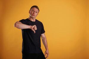 Unsatisfied,, showing ,dislike. Man is against background in the studio photo