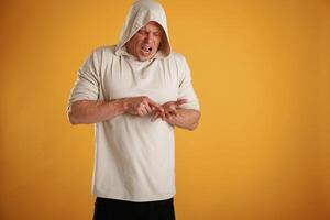 Angry, mad, showing something on the palm of the hand. Man is against background in the studio photo