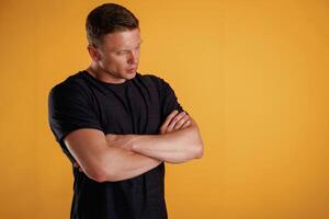 Standing, with arms crossed. Man is against background in the studio photo