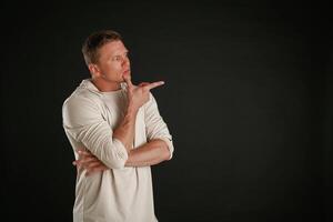 New product, showing at copy space. Man is against background in the studio photo