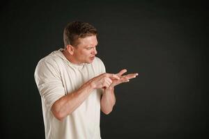 Take a look at this, copy space, showing on the palm of hand. Man is against background in the studio photo