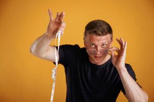 Measuring ,,tape in hand, fitness conception. Man is against background in the studio photo
