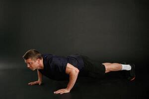 Push ,ups exercise. Man is against background in the studio photo