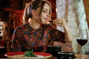 Woman is, in, the restaurant with food and drink photo