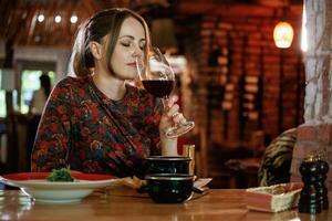Big, glass of wine, drinking. Woman is in the restaurant with food and drink photo