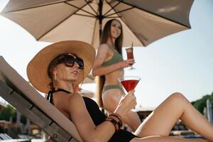 Resort conception, relaxing.,., Two beautiful women are resting near the pool photo