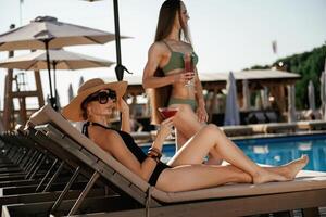 Resort conception, relaxing... Two ,beautiful women are resting near the pool photo
