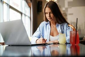 Front ,view. Beautiful ,woman with laptop is in the bar photo