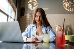 Front view. Beautiful woman ,,with ,laptop is in the bar photo