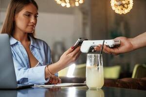 Using ,smartphone. Woman is paying for, the service in the restaurant photo