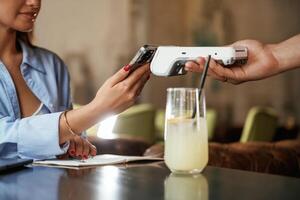 Using ,smartphone. Woman is ,paying for the service in the restaurant photo