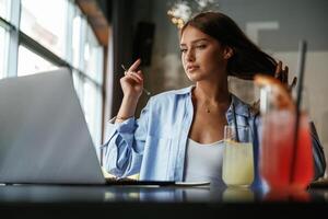 Front, view. .Beautiful woman with laptop is in the bar photo