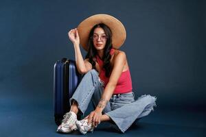 Vacation time, sitting ,with, suitcase. Beautiful young woman is against background photo