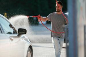 Washing ,,the, automobile. Man is with his car outdoors.. photo