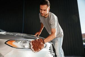 Focused at washing the automobile. Man is with his car outdoors photo
