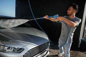 Side ,view, car wash,,,, high pressure. Man is with his automobile outdoors photo